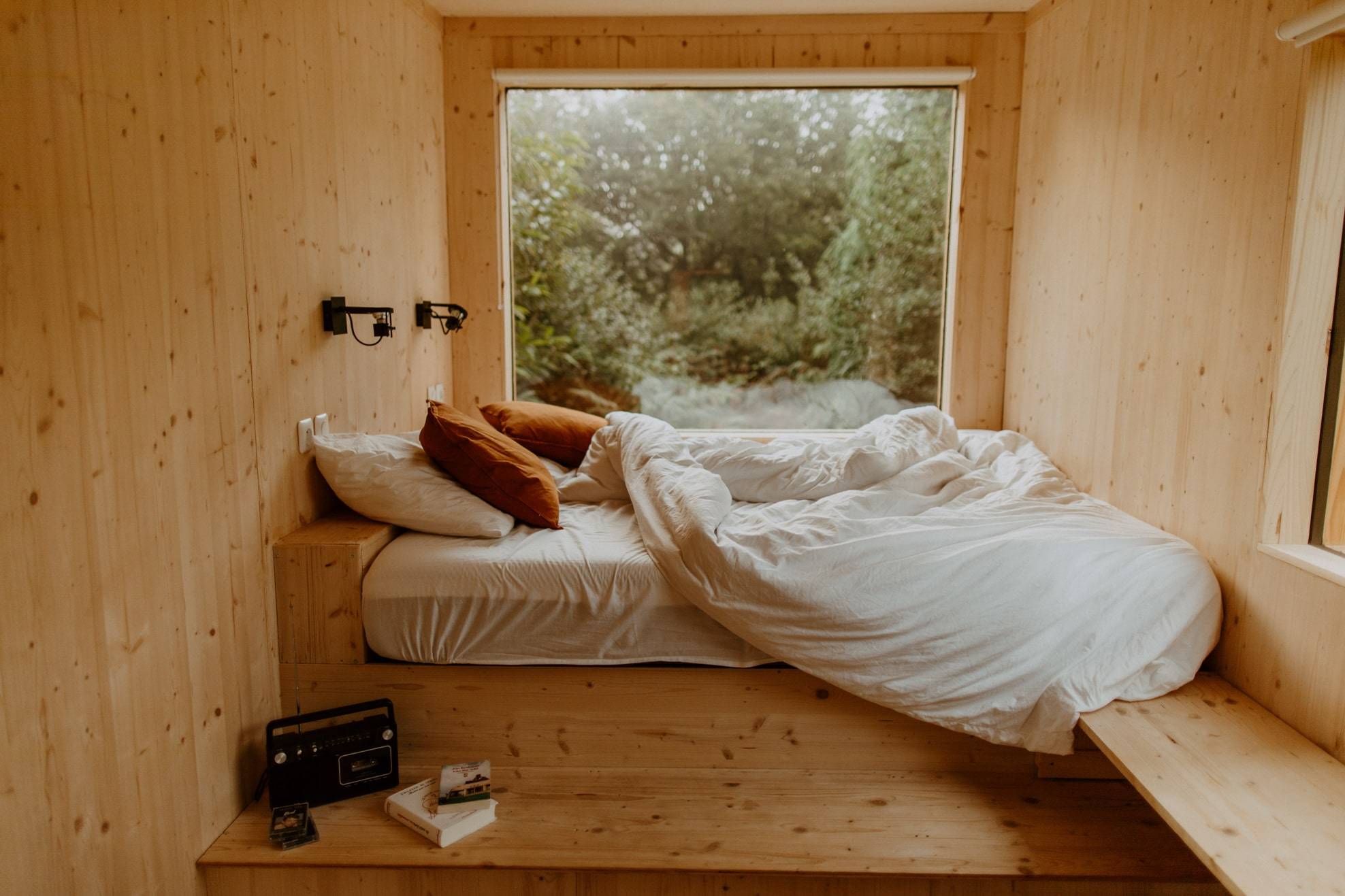 Lit avec la couette en boule et une vue sur la nature