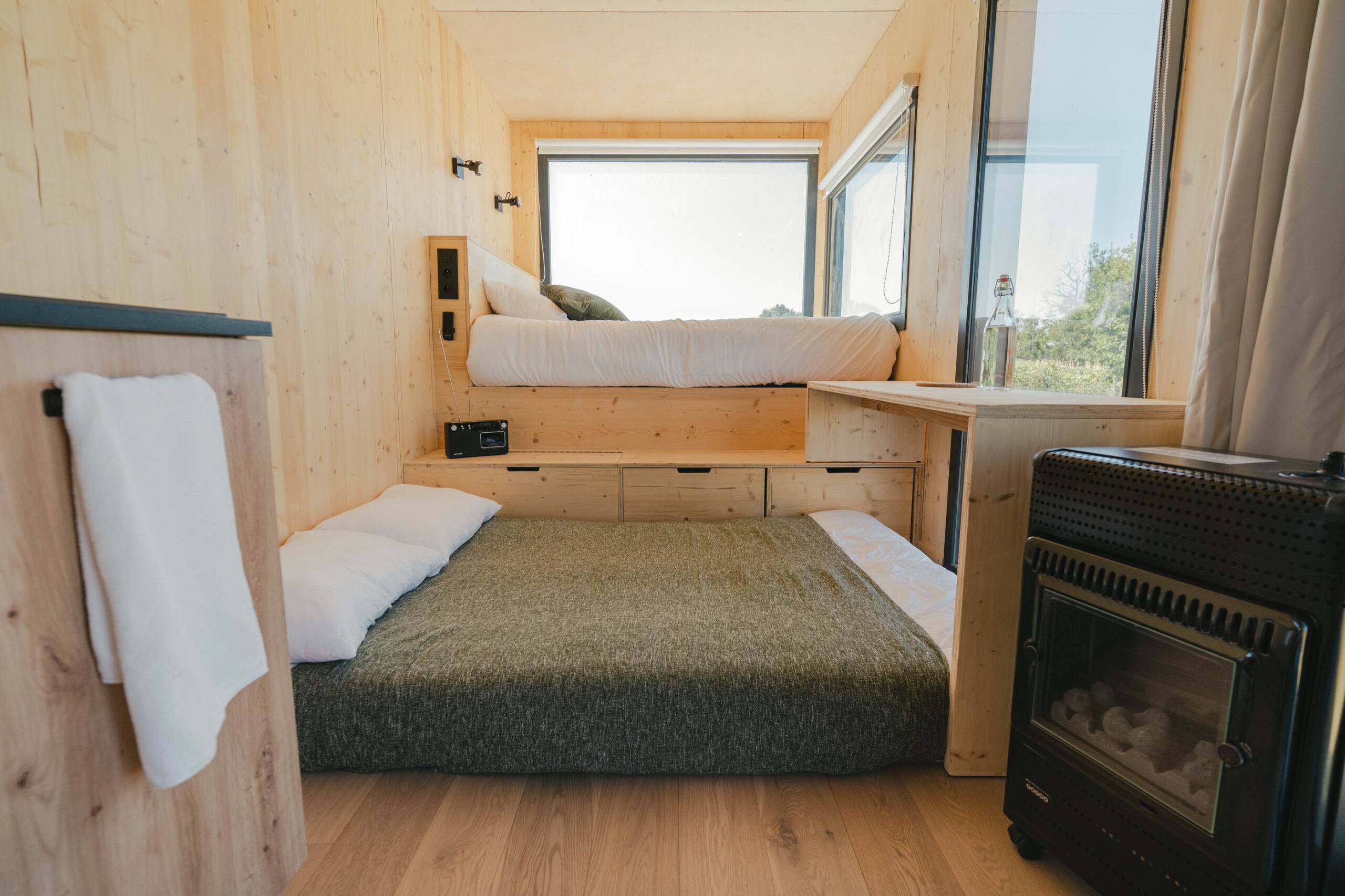 Blick auf das Bett und den Futon vom Tiny House aus
