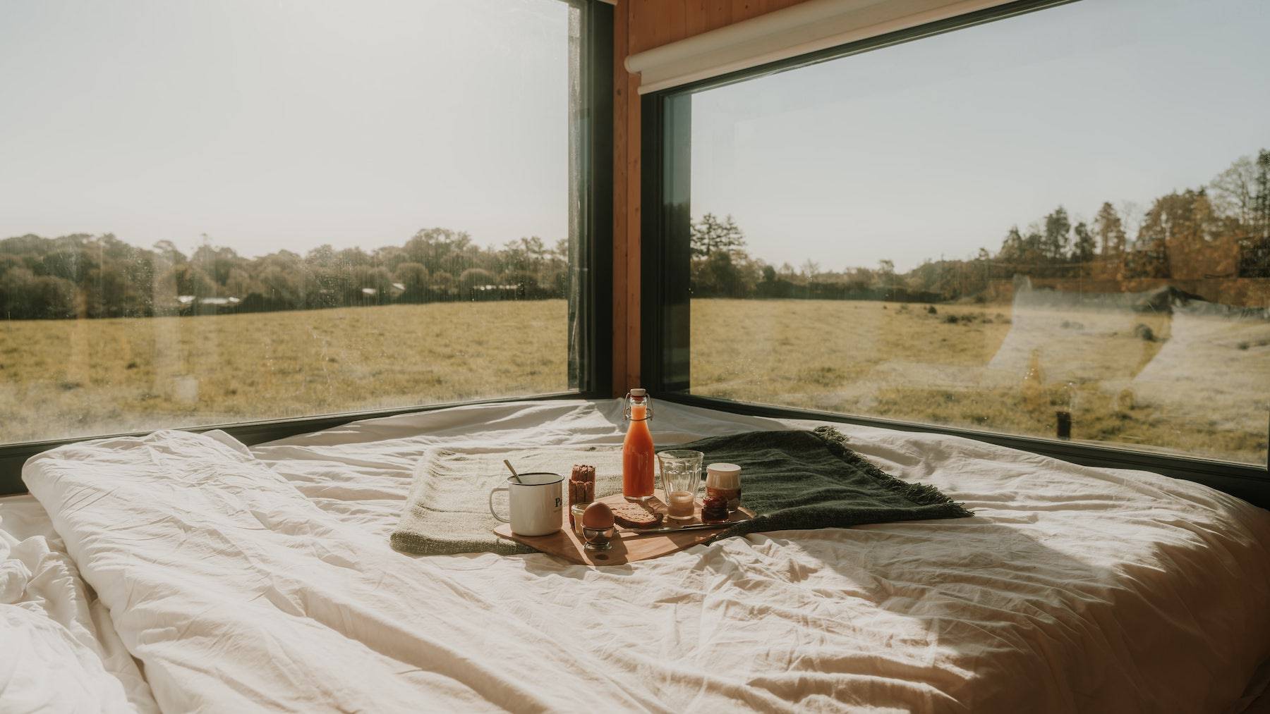 Petit déjeuner posé sur le lit dans la Tiny House