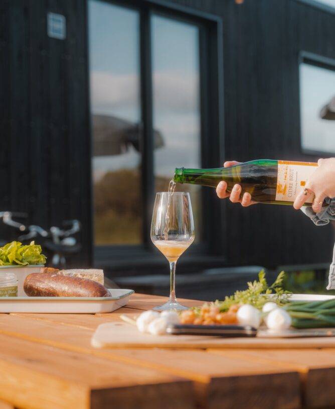 Woman pouring cider into her glass for the aperitif