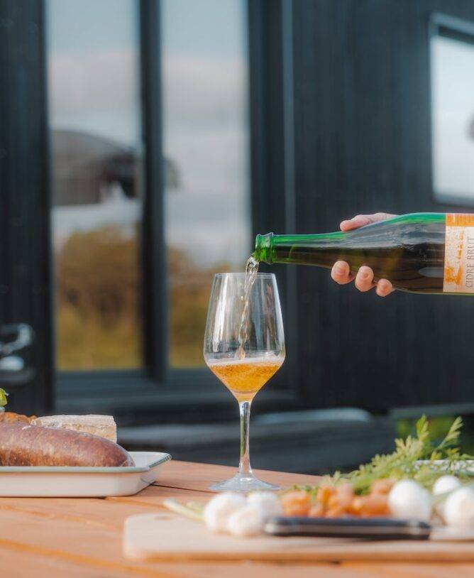 Femme qui verse du cidre dans son verre pour l'apéro
