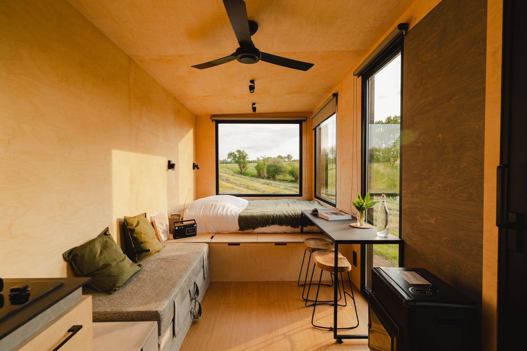 View of the Tiny House bed, table and futon