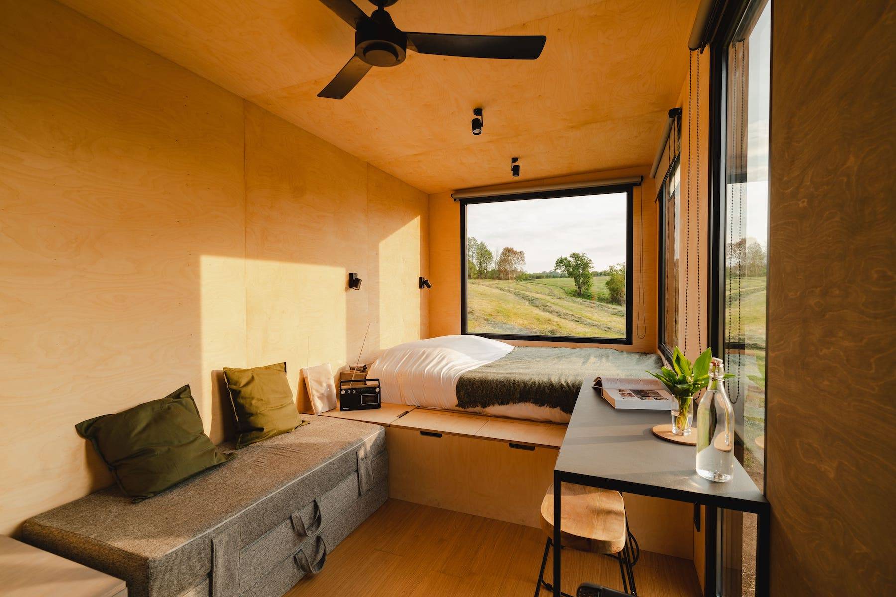View of the Tiny House bed, table and futon