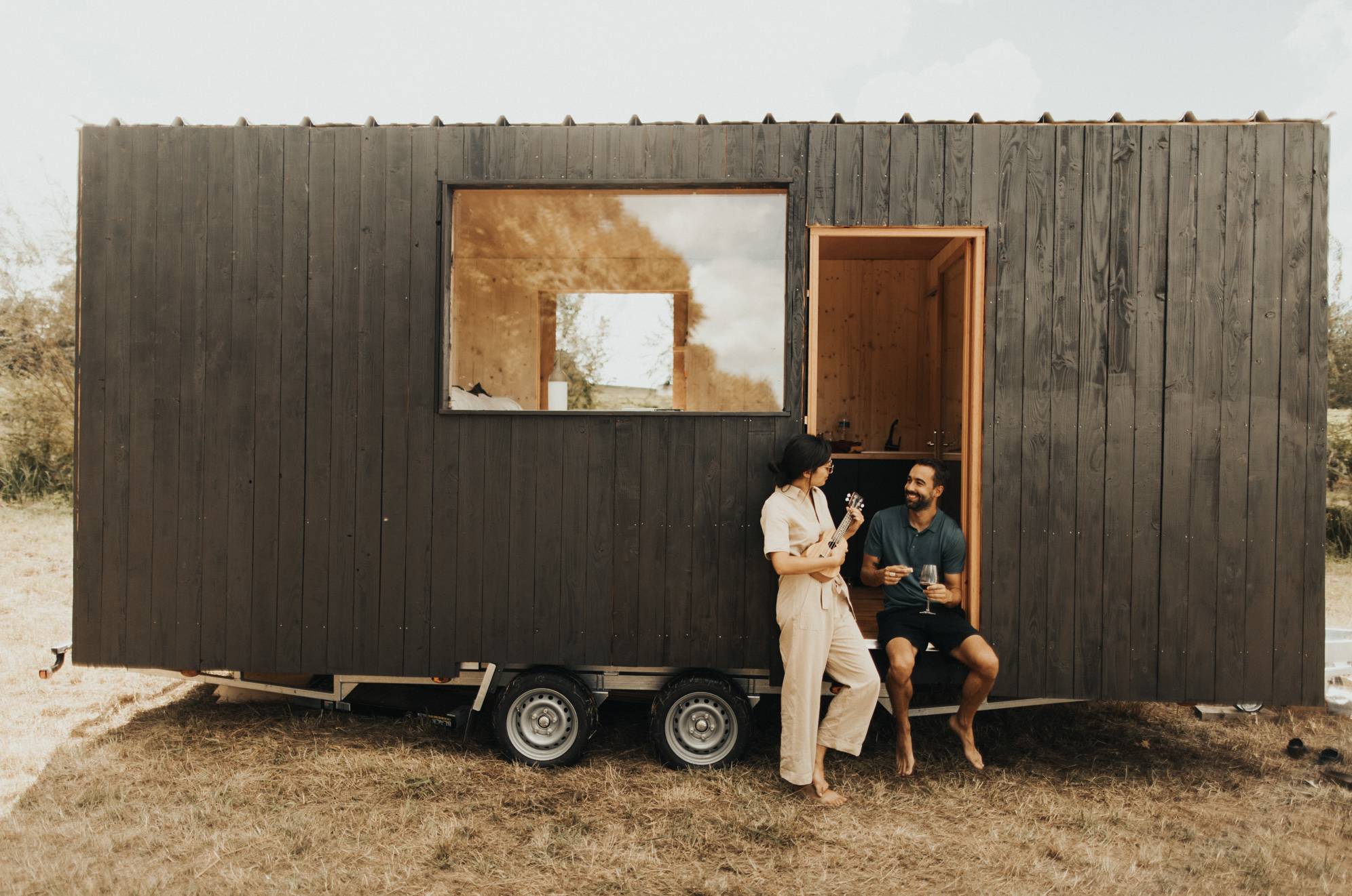 Gitarre spielendes Paar vor dem Tiny House in Saint Emilion
