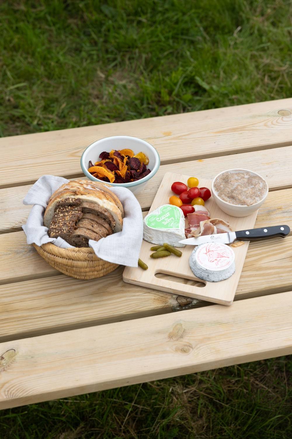 Se sirve un aperitivo con queso local en una mesa de picnic de madera.